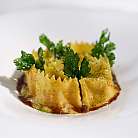 Pasta ripiena con erbe verdi e salsa su piatto bianco